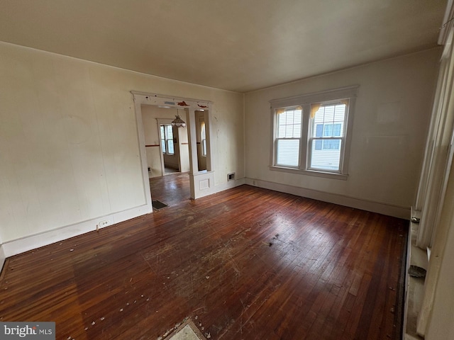 spare room featuring plenty of natural light and dark hardwood / wood-style flooring