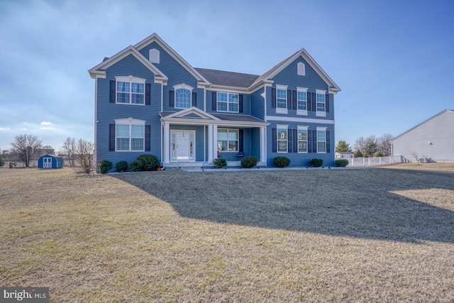 view of front of home featuring a storage unit and a front lawn