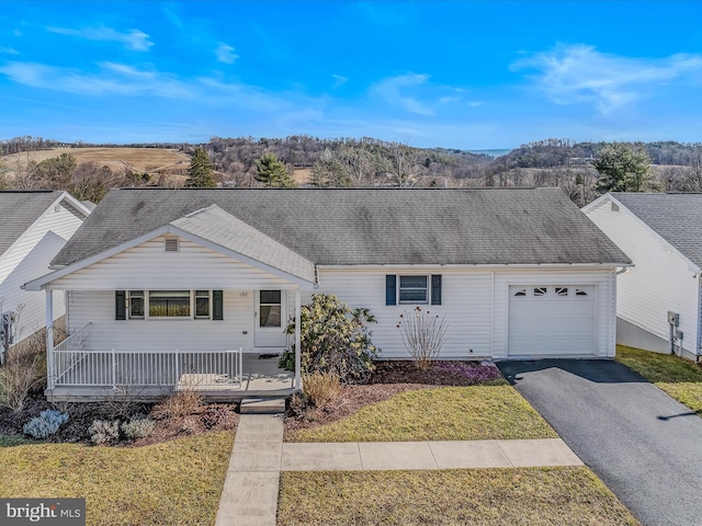 ranch-style home featuring a garage, a front lawn, and a porch