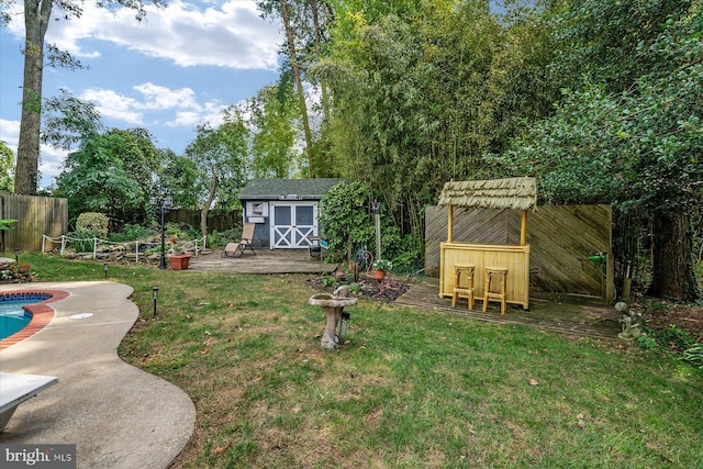 view of yard with a bar, a storage shed, a patio area, and a fenced in pool