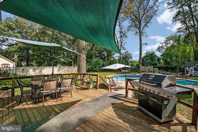 wooden deck with a fenced in pool and a storage unit