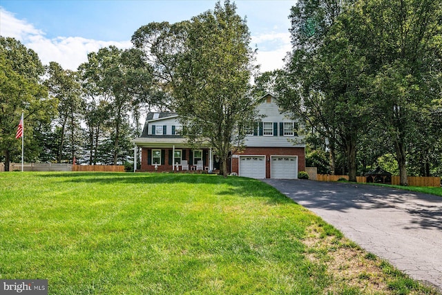 view of front of house with a porch, a garage, and a front yard