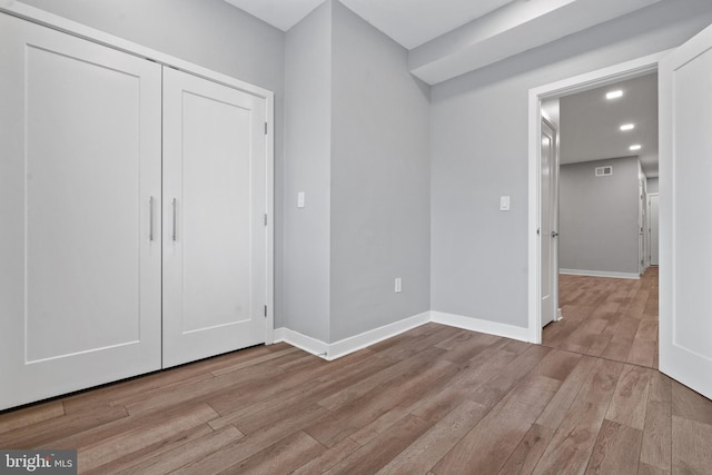 unfurnished bedroom with a closet and light wood-type flooring