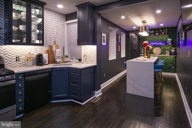 kitchen with dark wood-type flooring, hanging light fixtures, a kitchen breakfast bar, stainless steel range with gas stovetop, and black dishwasher