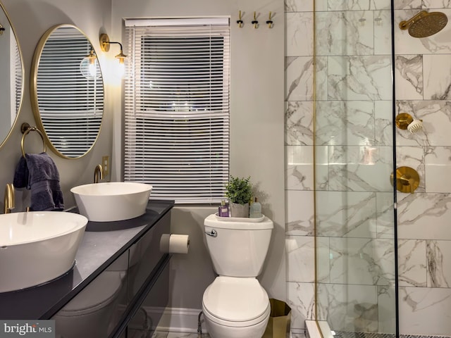 bathroom featuring vanity, toilet, and tiled shower