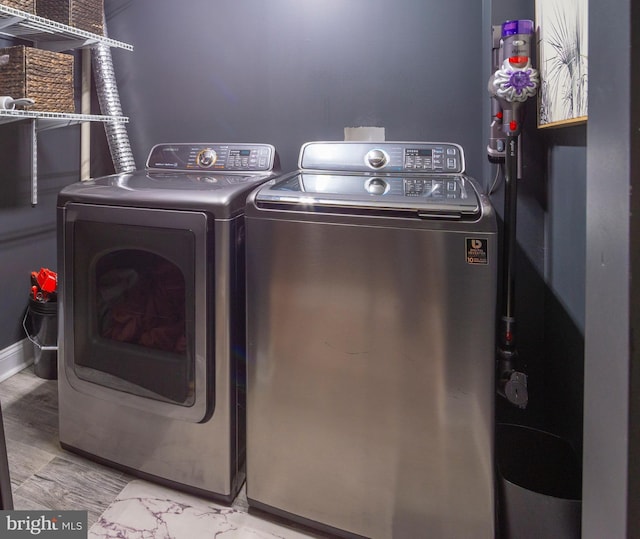 laundry room with light hardwood / wood-style flooring and washing machine and clothes dryer