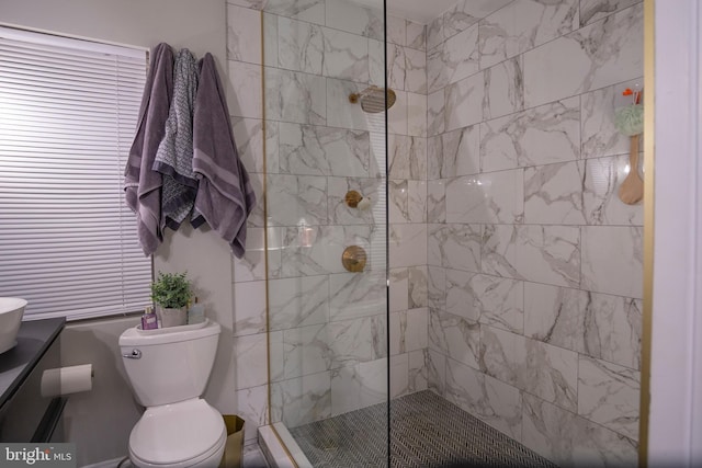 bathroom featuring vanity, tiled shower, and toilet