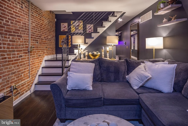 living room featuring hardwood / wood-style floors and brick wall