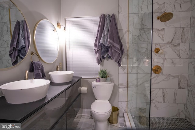 bathroom with tiled shower, vanity, and toilet