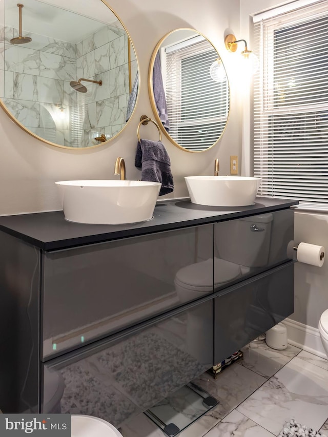 bathroom with vanity, a tile shower, and toilet