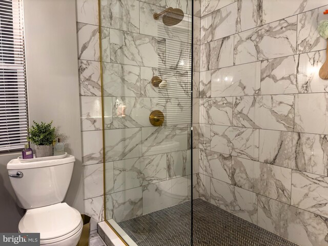 bathroom featuring a tile shower and toilet