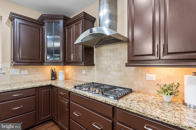 kitchen featuring stainless steel gas cooktop, decorative backsplash, and exhaust hood