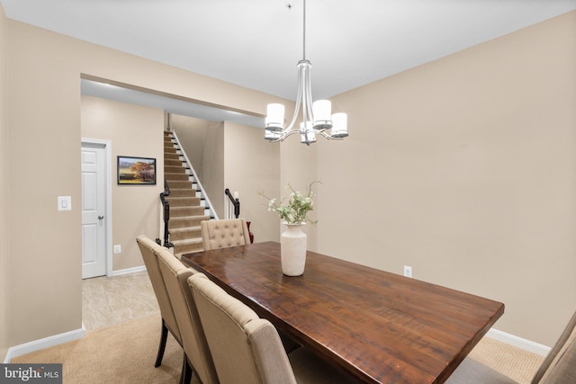 dining space with light carpet and an inviting chandelier