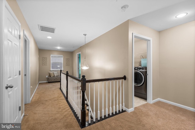 hall featuring washer / clothes dryer and light colored carpet