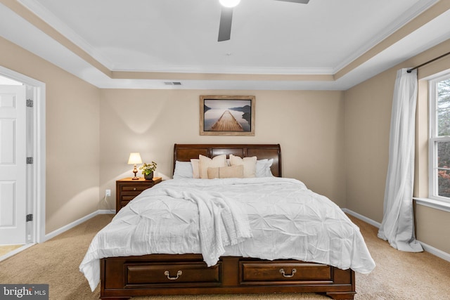 carpeted bedroom with a raised ceiling, ornamental molding, and ceiling fan