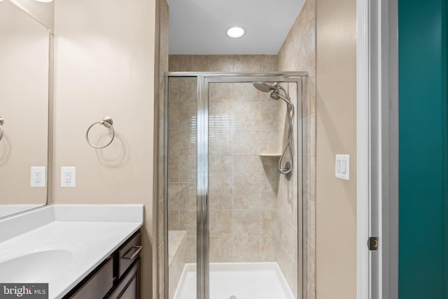 bathroom featuring vanity and a shower with shower door