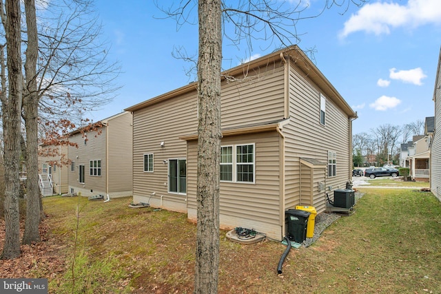 back of property with a lawn and central air condition unit