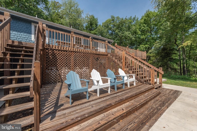 wooden terrace featuring stairway and view of scattered trees