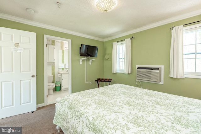 carpeted bedroom with a wall unit AC, ornamental molding, and connected bathroom