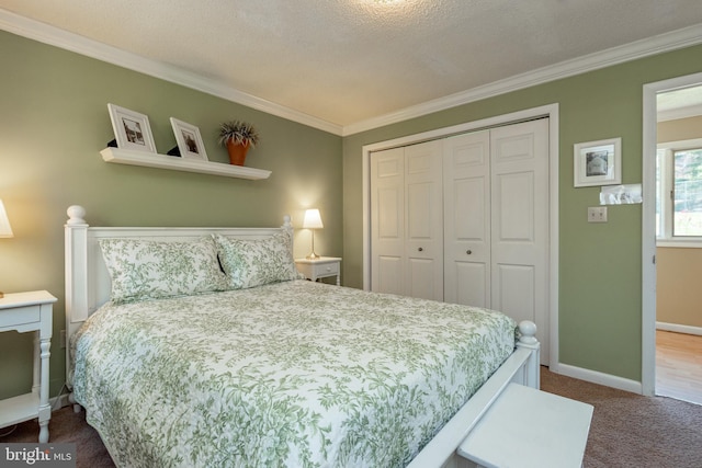 carpeted bedroom with ornamental molding, a closet, and baseboards
