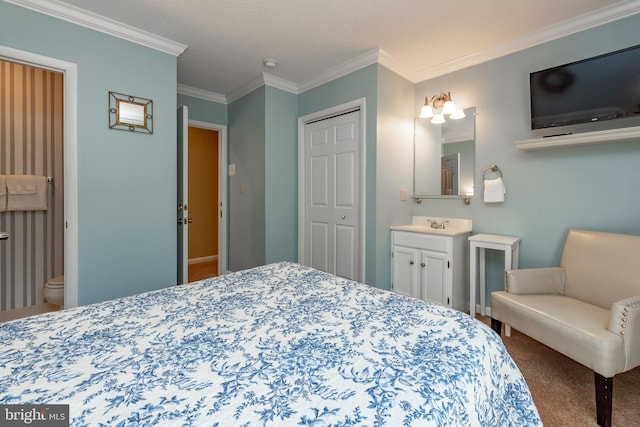 bedroom with ornamental molding, carpet, a closet, a sink, and connected bathroom