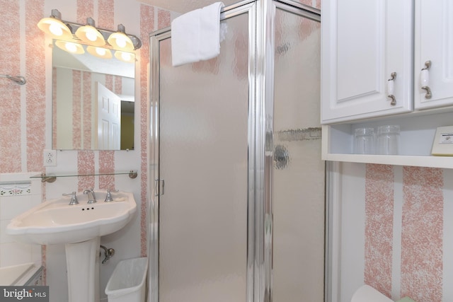 full bath with a stall shower, toilet, and wallpapered walls