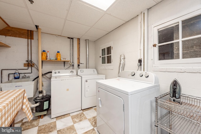 clothes washing area with washer and dryer and concrete block wall