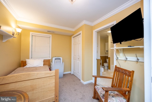 carpeted bedroom with ornamental molding, baseboards, and a closet