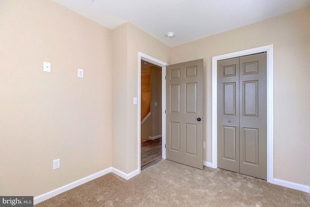 unfurnished bedroom featuring light colored carpet and a closet