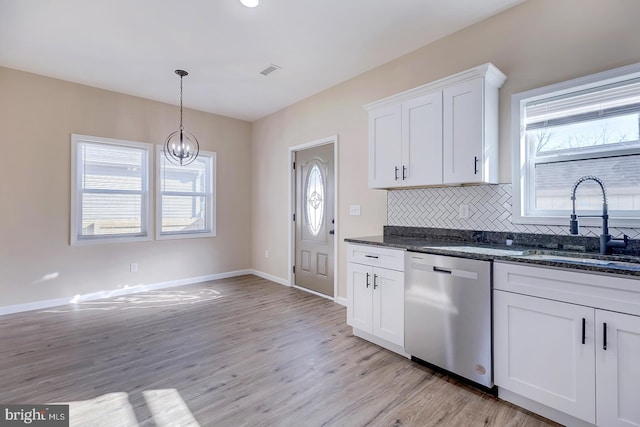 kitchen with dishwasher, sink, dark stone countertops, white cabinets, and decorative backsplash