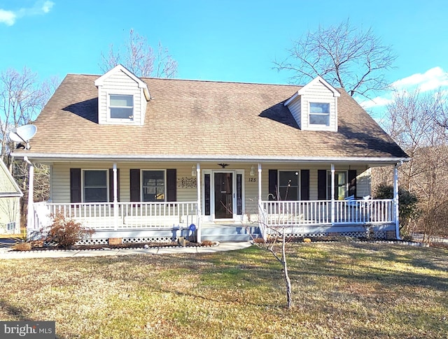 new england style home with a front yard and a porch