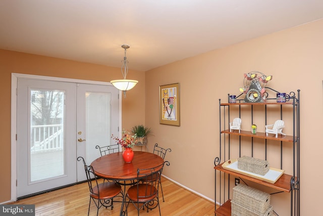 dining space with light hardwood / wood-style floors and french doors