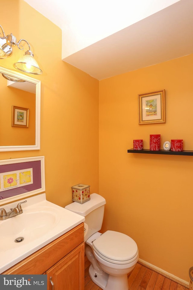 bathroom featuring hardwood / wood-style flooring, vanity, and toilet