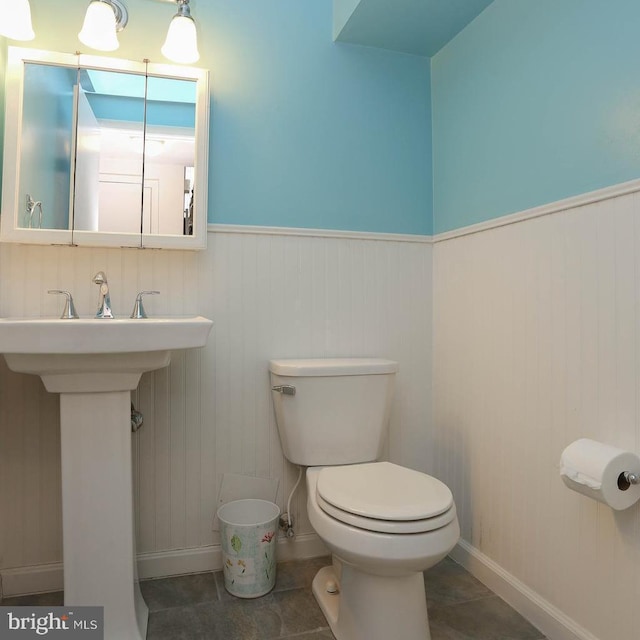 bathroom with sink, toilet, and tile patterned flooring