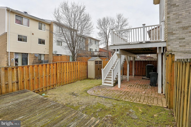 view of yard featuring a patio area, a deck, and a storage unit