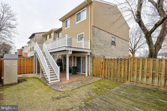 rear view of house featuring a wooden deck, a yard, central AC unit, and a shed