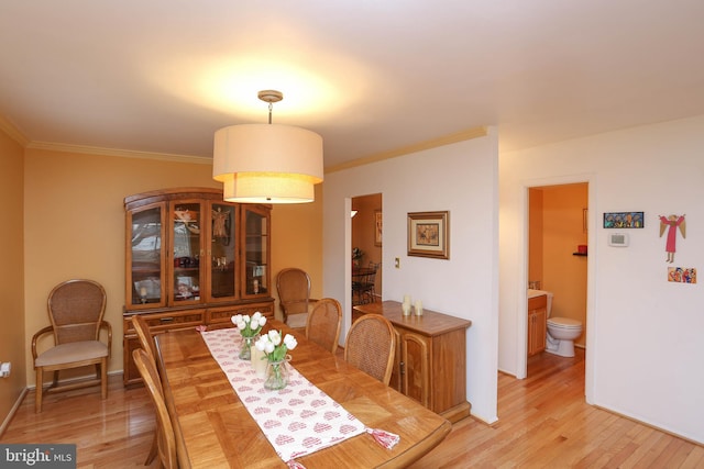 dining area featuring crown molding and light hardwood / wood-style flooring