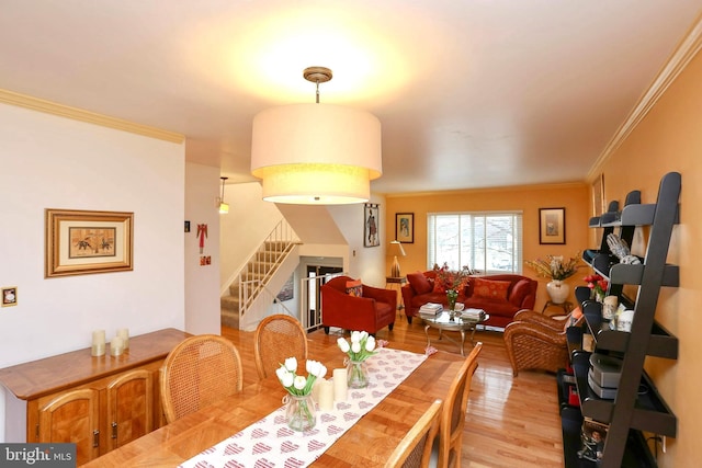 dining room with crown molding and light hardwood / wood-style flooring