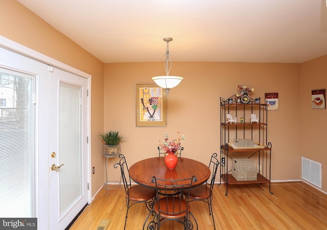 dining room with hardwood / wood-style flooring and french doors