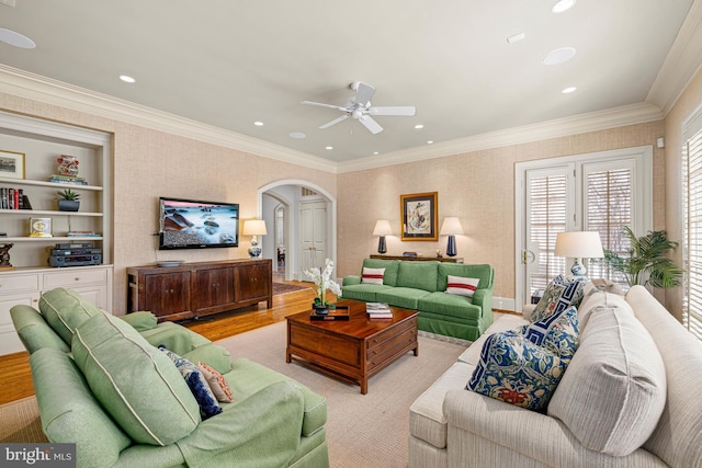 living room featuring ornamental molding, built in features, and ceiling fan