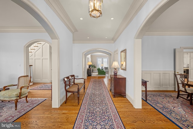 hallway with crown molding and light wood-type flooring