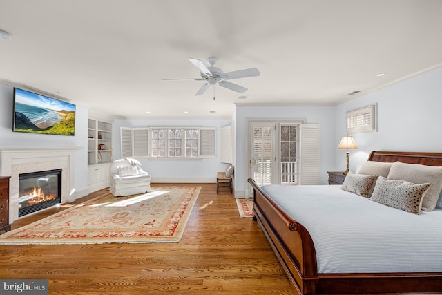 bedroom with access to exterior, wood-type flooring, and ceiling fan