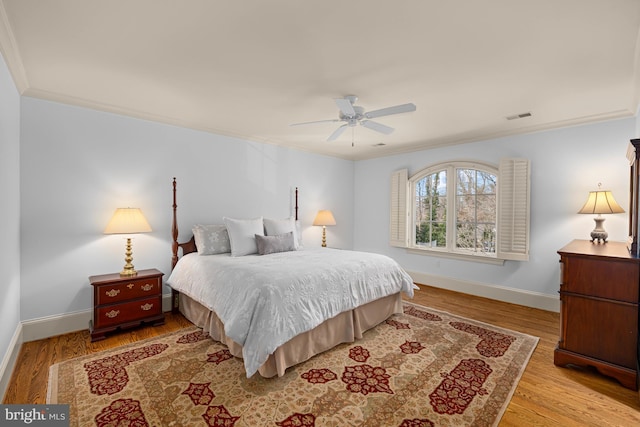 bedroom featuring ornamental molding, light hardwood / wood-style floors, and ceiling fan