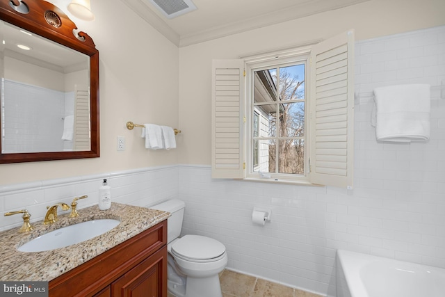 bathroom featuring tile walls, vanity, ornamental molding, a tub to relax in, and toilet