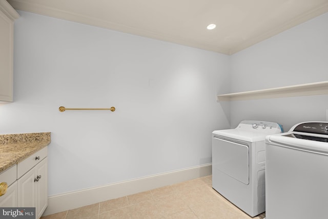 laundry room with separate washer and dryer, light tile patterned floors, and cabinets