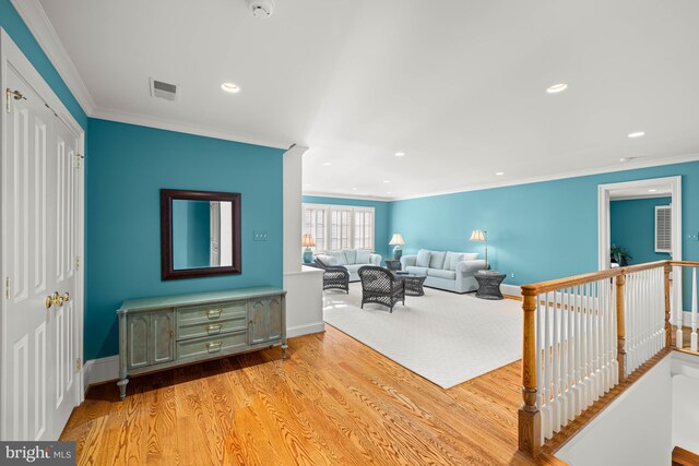 living room with crown molding and light hardwood / wood-style floors