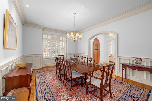 dining space featuring an inviting chandelier, crown molding, and light hardwood / wood-style floors