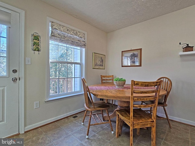 dining room with tile patterned floors and a textured ceiling