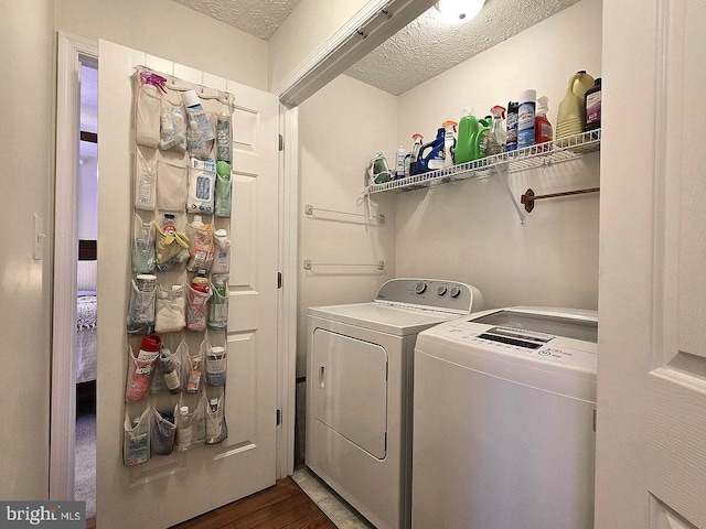 laundry room with dark hardwood / wood-style flooring, washer and dryer, and a textured ceiling