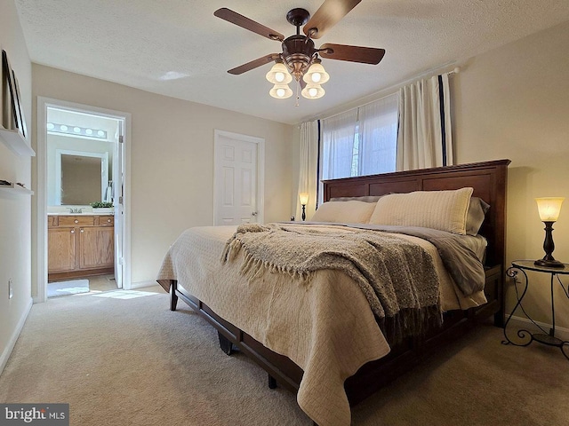 carpeted bedroom featuring ceiling fan, connected bathroom, and a textured ceiling